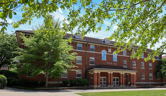 Exterior view of Bowen Hall, a multi-story brick residence hall with a central entrance, large windows, and a landscaped courtyard.