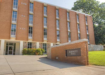 Brick building with a brick sign at the front entrance saying "Barnett Hall"
