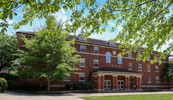Exterior view of Bowen Hall, a multi-story brick residence hall with a central entrance, large windows, and a landscaped courtyard.